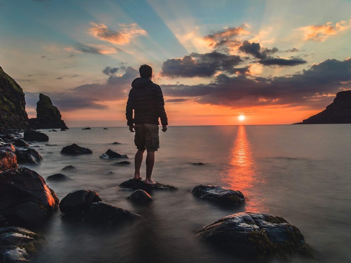 Man Looking at Sunset over Ocean